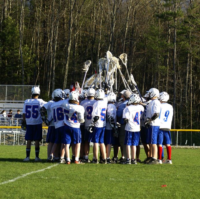 A high school lacrosse team huddled together after bonding on a coach bus.