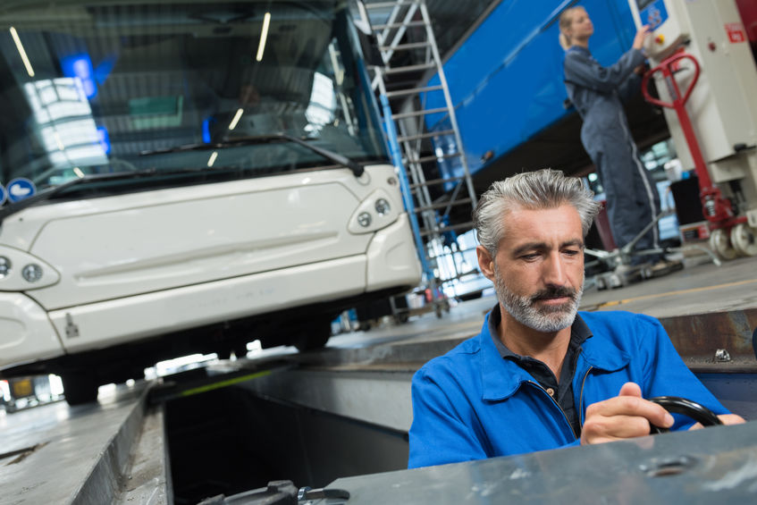 man fixing and repairing coach bus