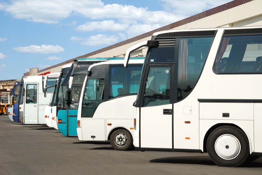 bus fleet sitting in parking lot